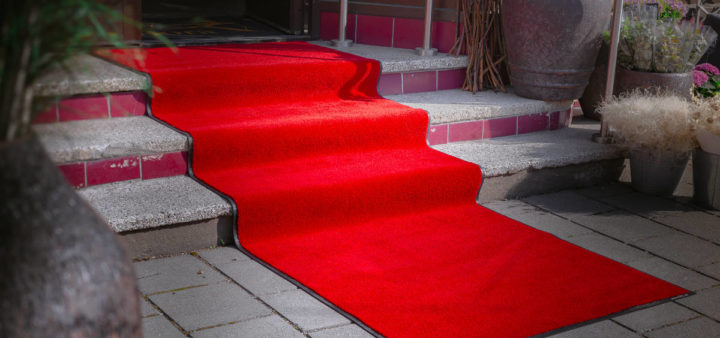 En rød løper ned trapper utenfor en butikk